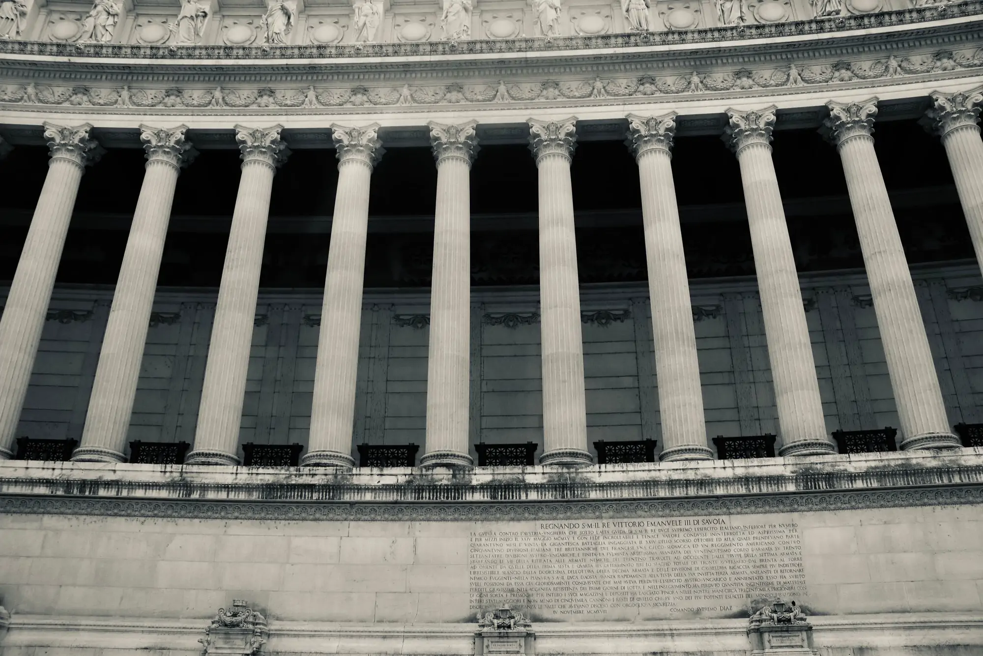 Repeating stone facade of a government building, shot from below against overcast sky