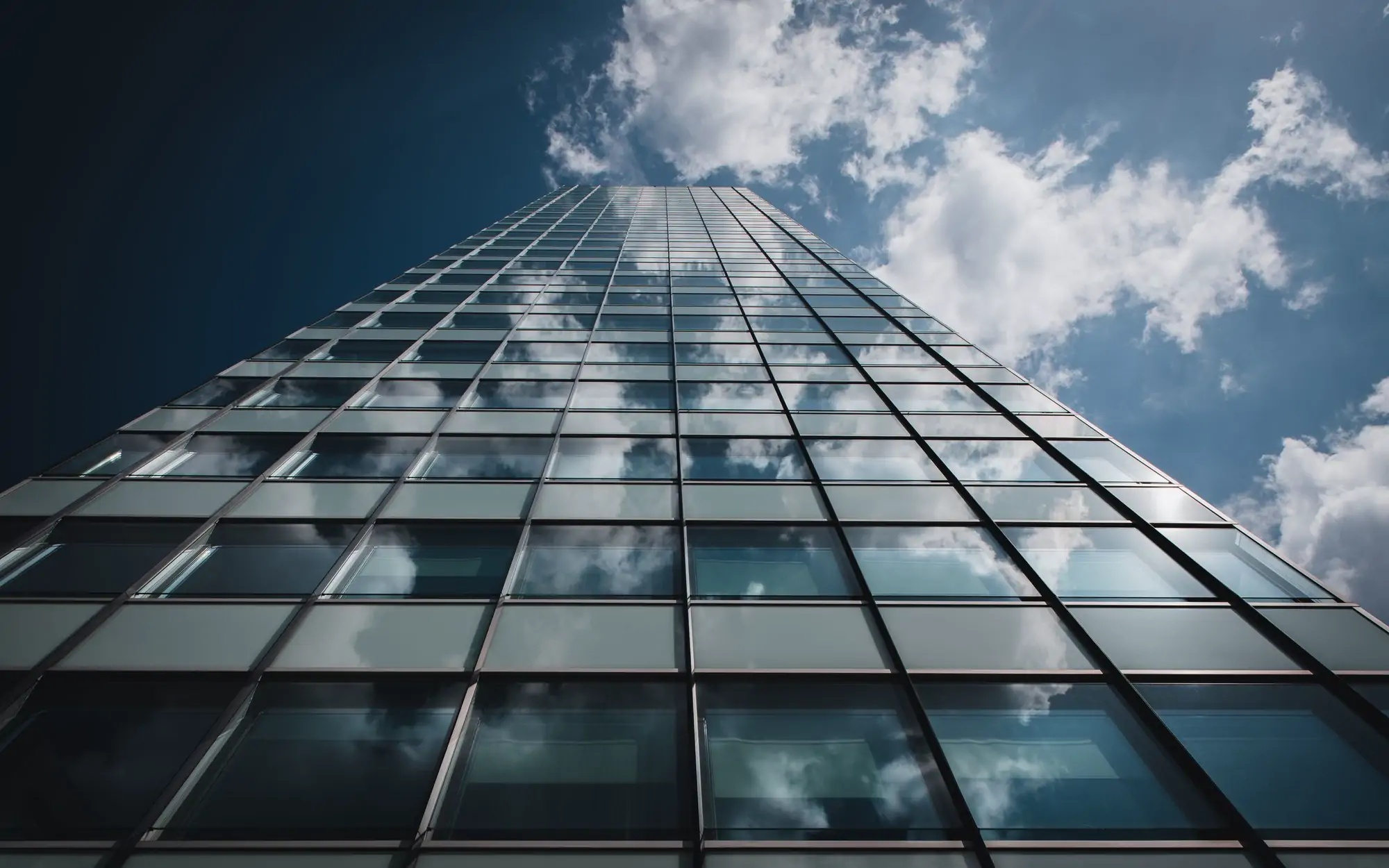 Glass and steel facade of a City office building reflecting a grey sky