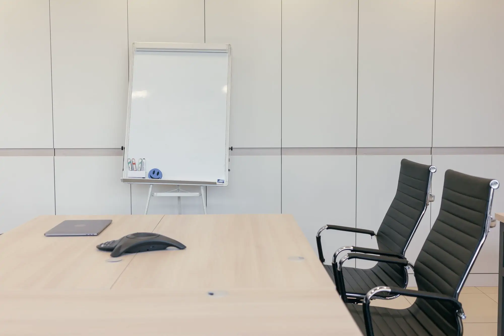Empty modern meeting room with a long table and floor-to-ceiling windows