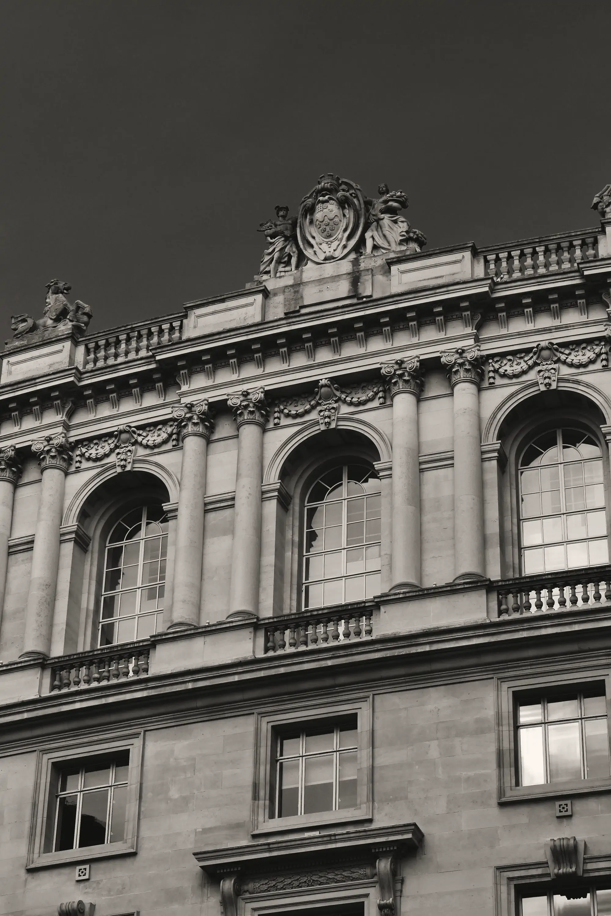 Classical stone columns of a government building rising against an overcast sky