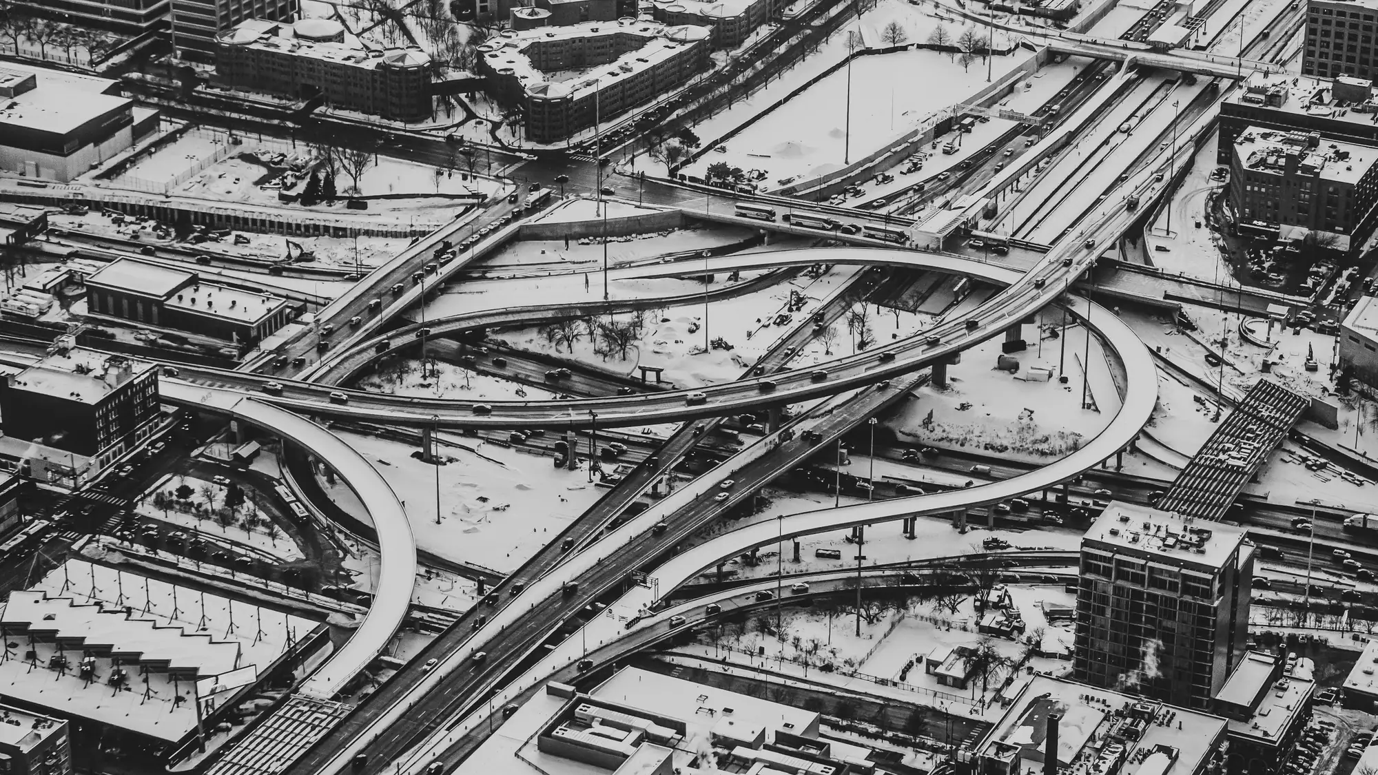 A multi-level road interchange from the air in black and white, routes crossing and branching at several heights.