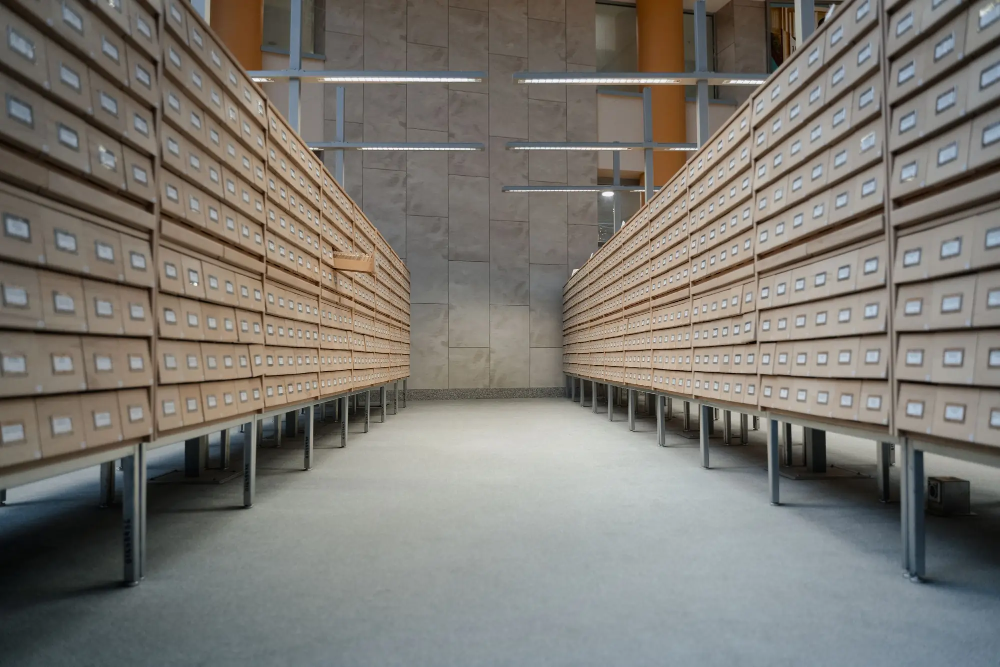 A long archive aisle lined floor to ceiling with wooden index drawers.